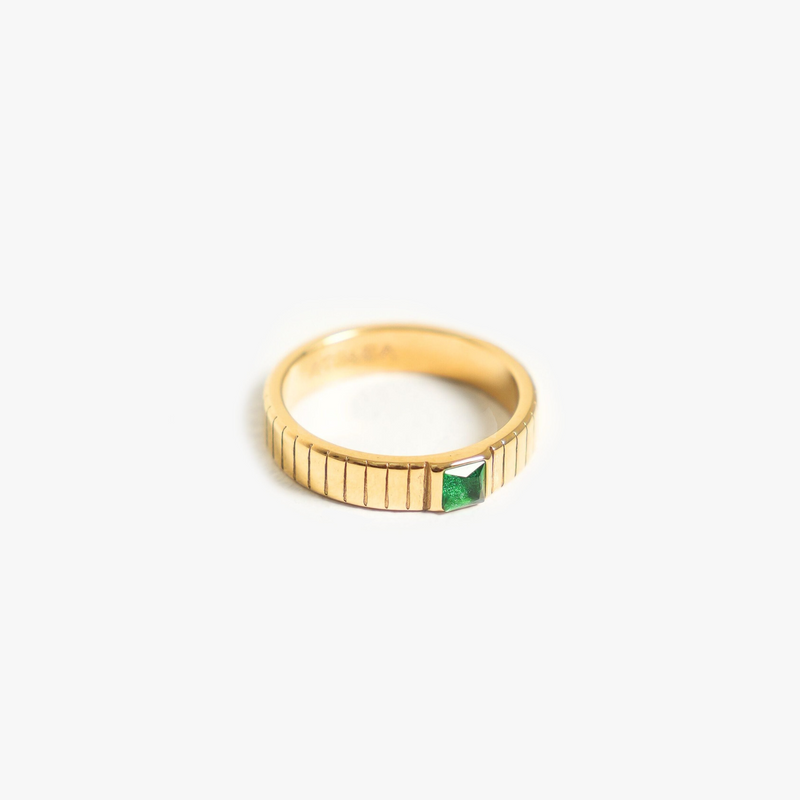 a gold ring with a green stone in the middle