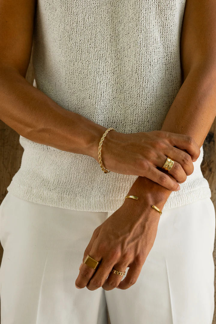 a close up of a person wearing gold rings