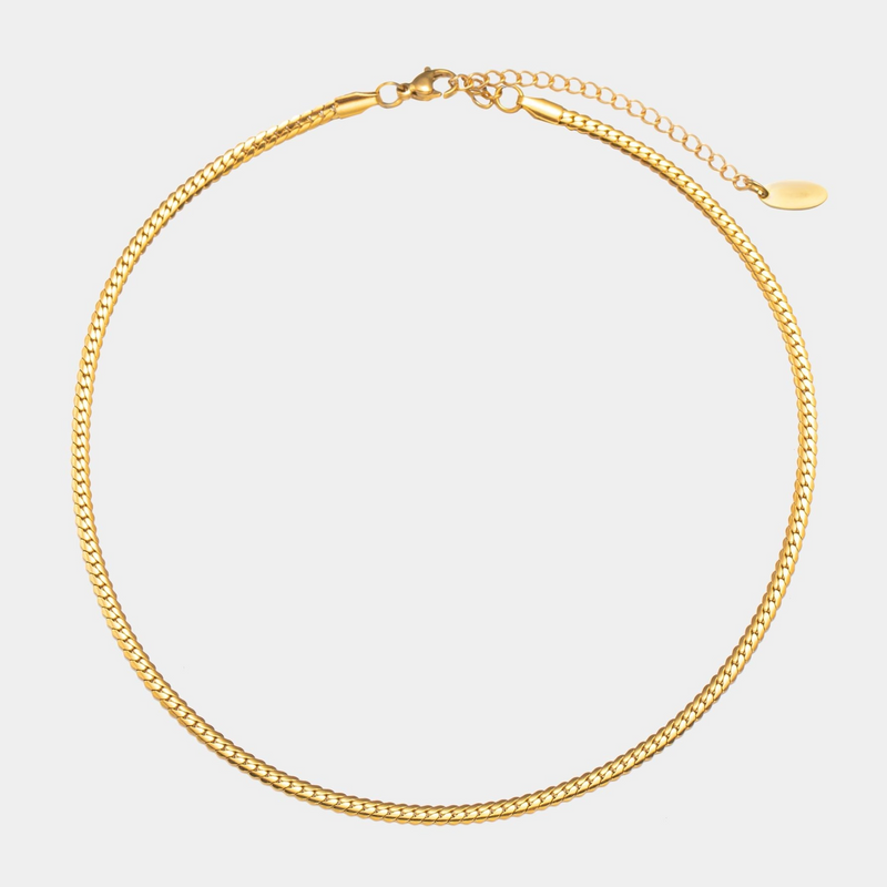 a gold chain bracelet on a white background