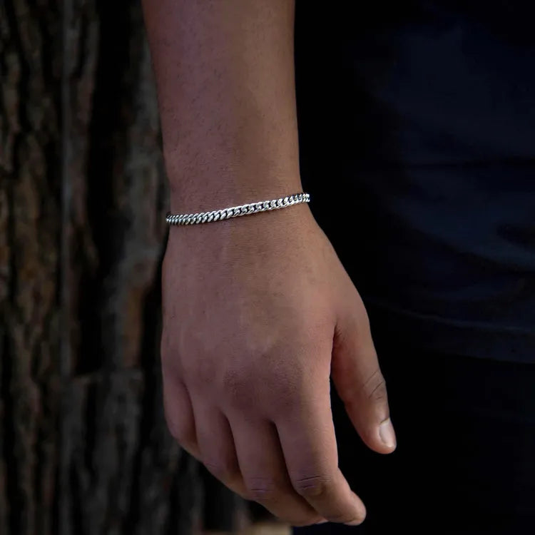 a person wearing a bracelet with a chain on it