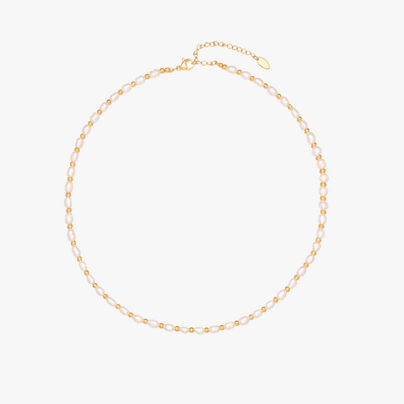 a gold necklace with pearls on a white background