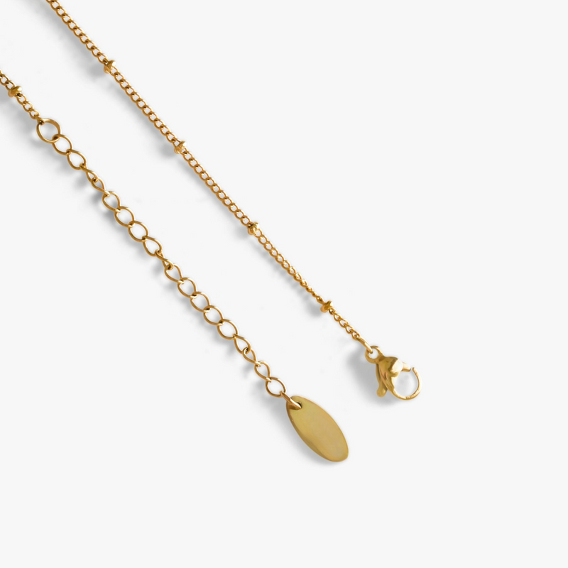 a pair of gold necklaces on a white background