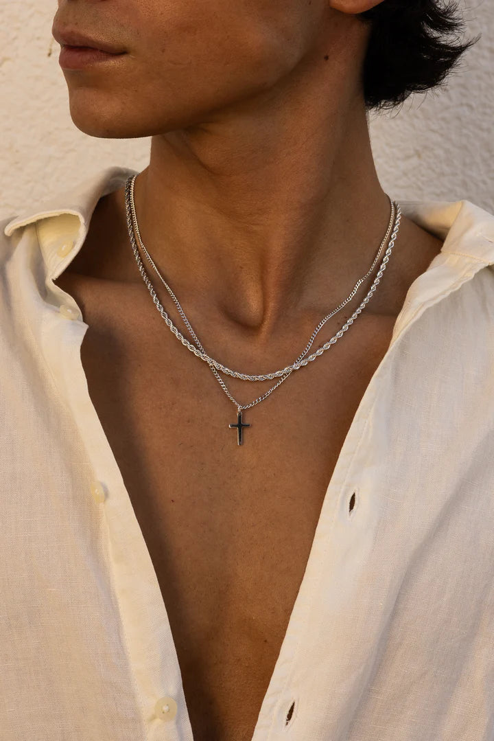 a man wearing a white shirt and a cross necklace