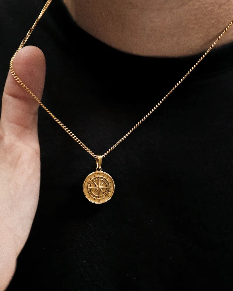 a man wearing a gold necklace with a medallion on it