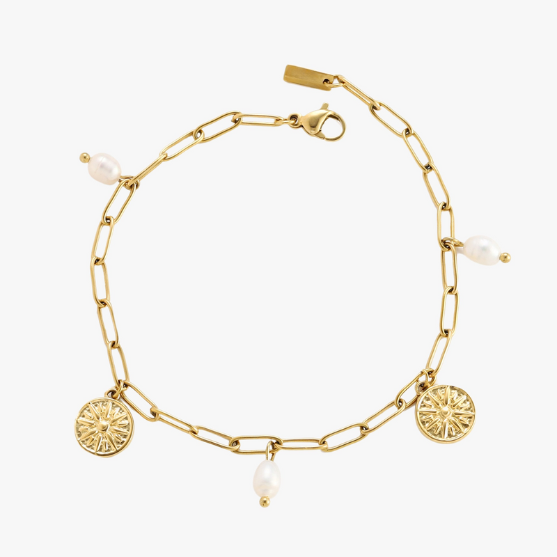 a gold bracelet with charms and pearls