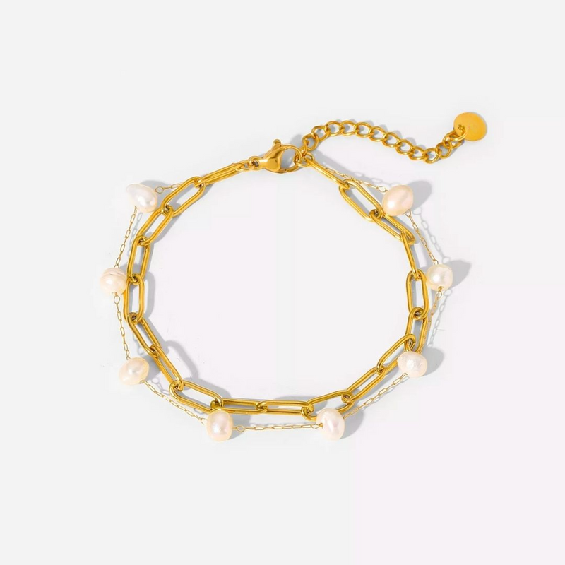 a gold chain bracelet with pearls on it