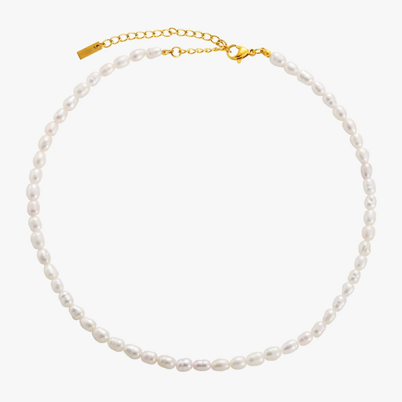 a white pearl necklace on a gold chain