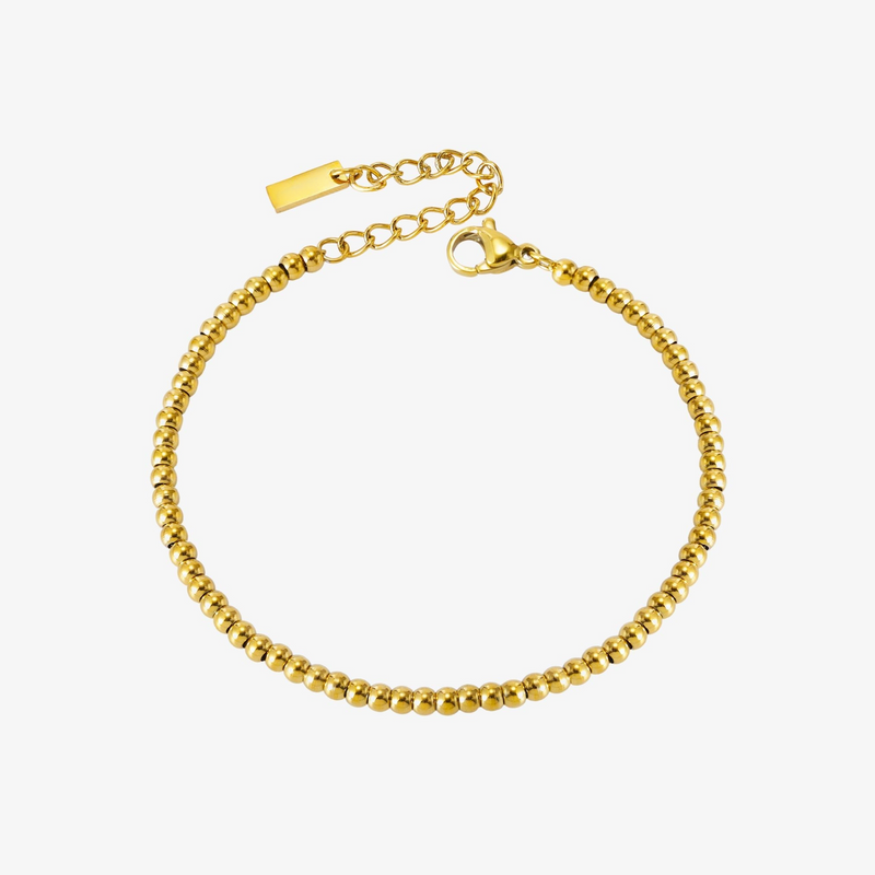 a gold beaded bracelet on a white background