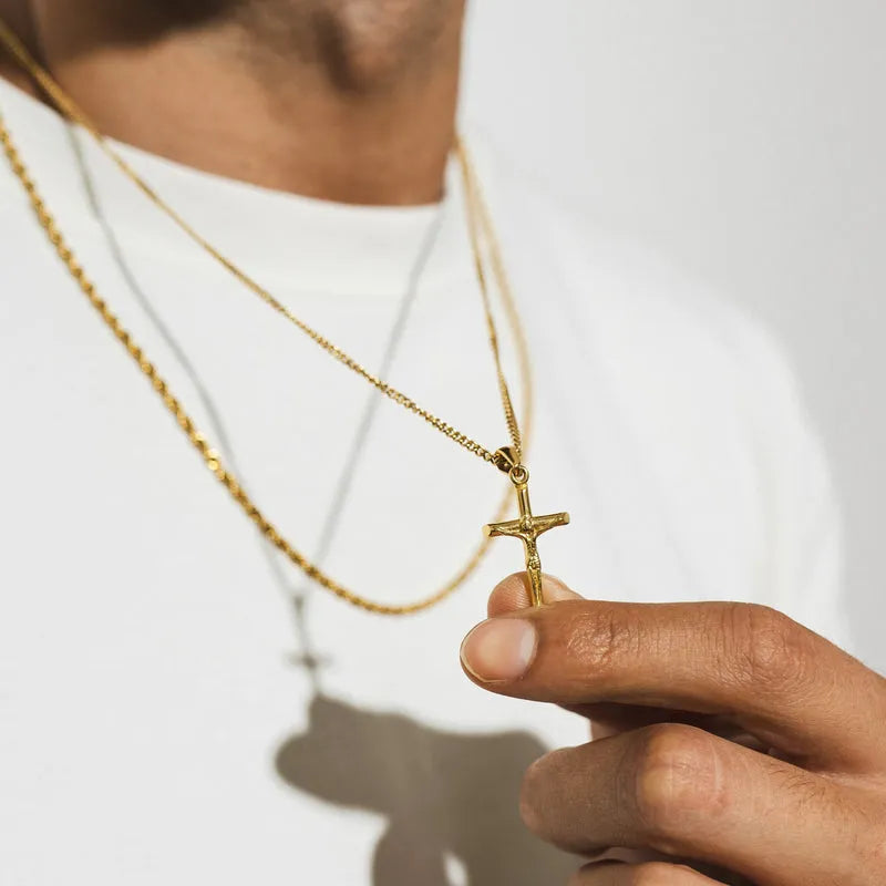 a man holding a cross necklace in his hand