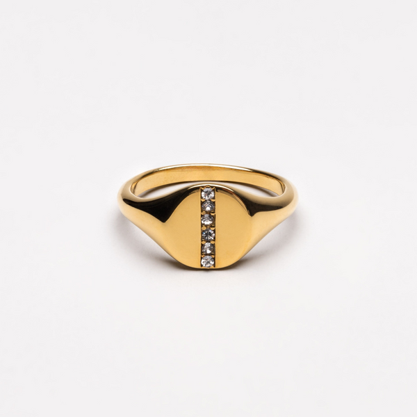 a gold signet ring with a row of diamonds