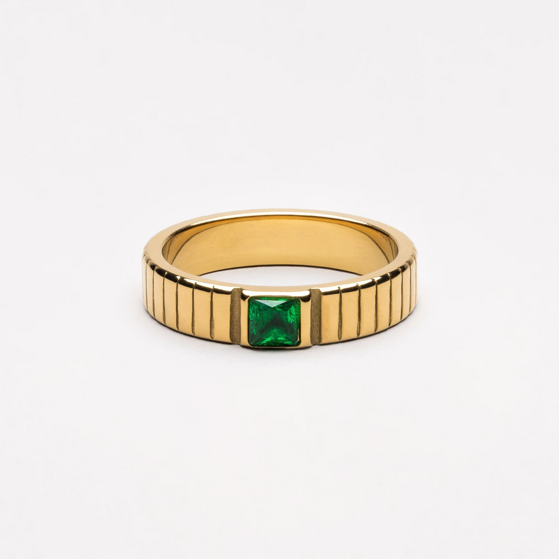 a gold ring with a green stone in the middle