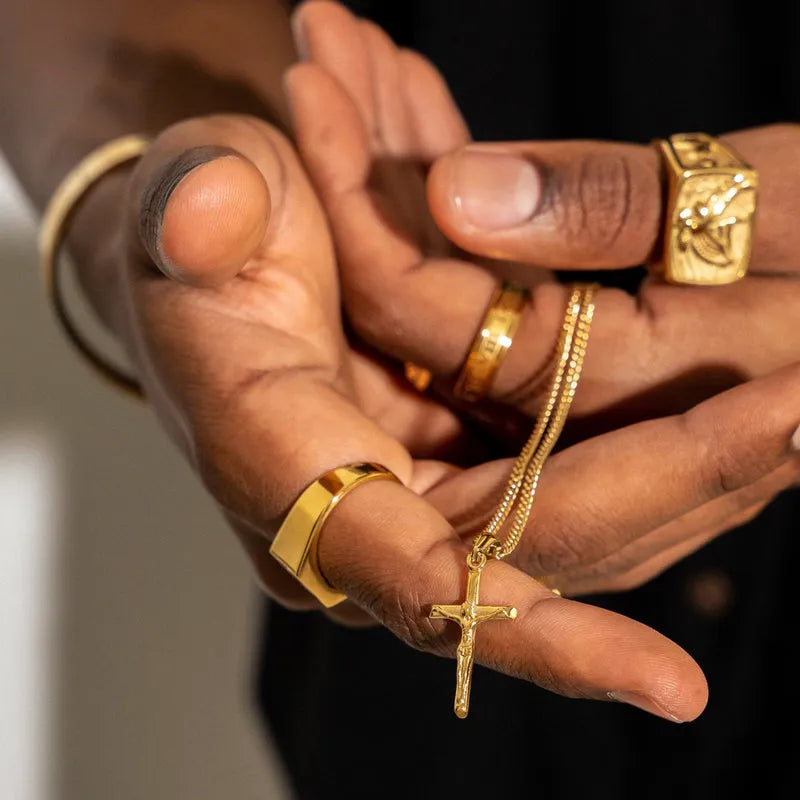 a person holding a cross and a chain in their hands