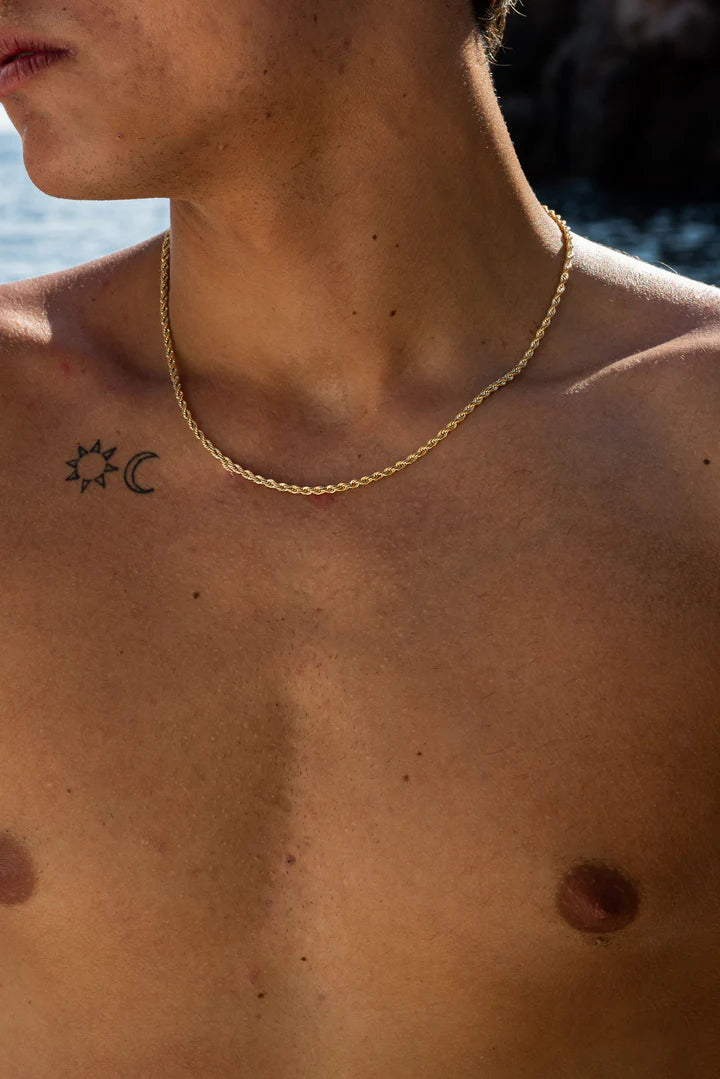 a man with a sun and moon tattoo on his chest