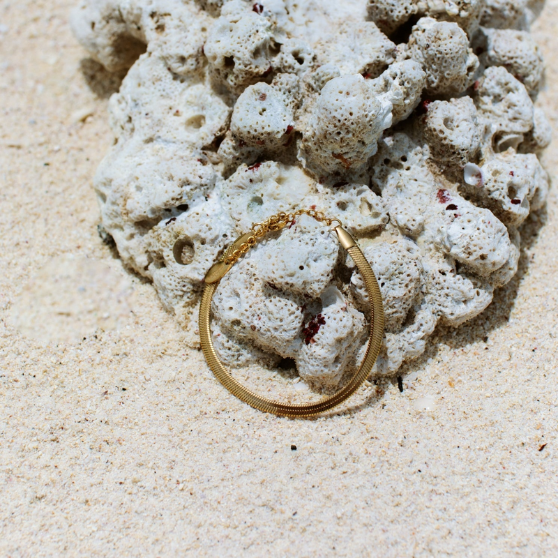 a gold wedding ring sitting on top of a pile of rocks