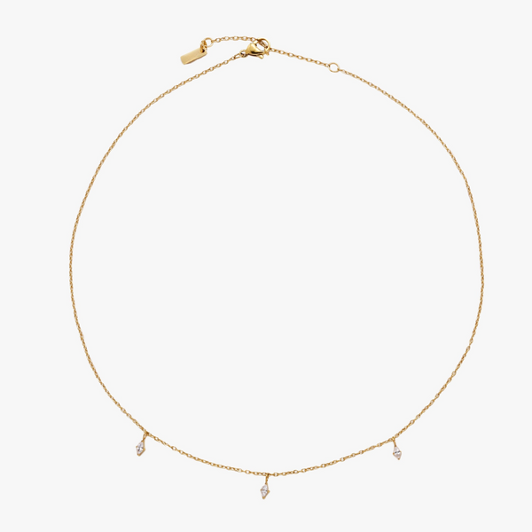 a gold necklace with three diamonds on a white background