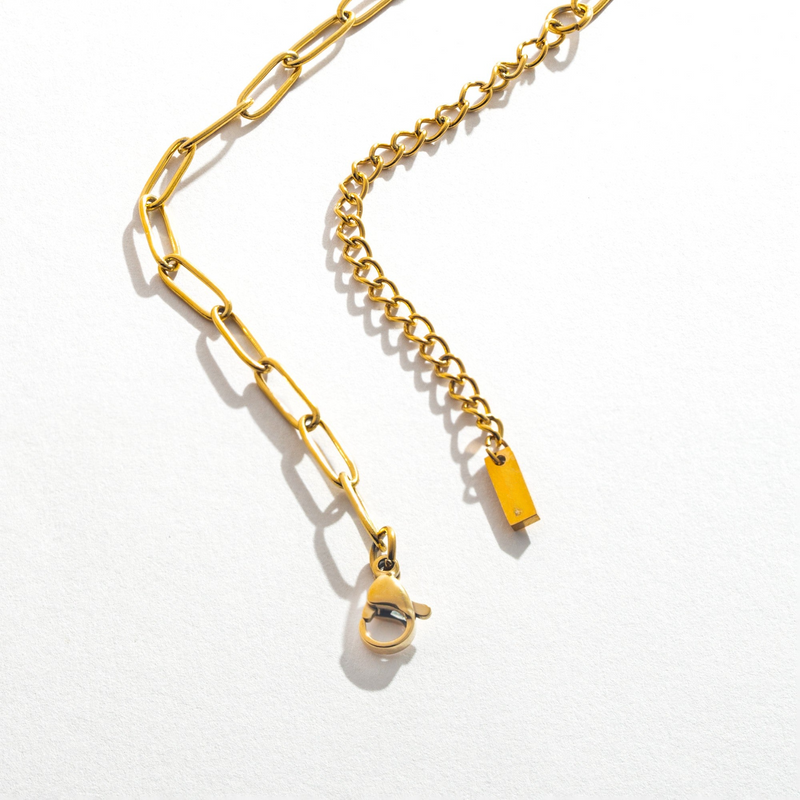 a gold chain with a yellow tag hanging from it