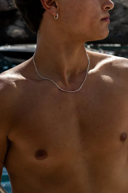 a man with no shirt standing in front of a pool