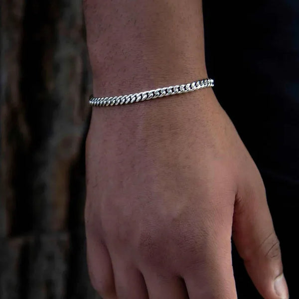 a person wearing a bracelet with a chain on it