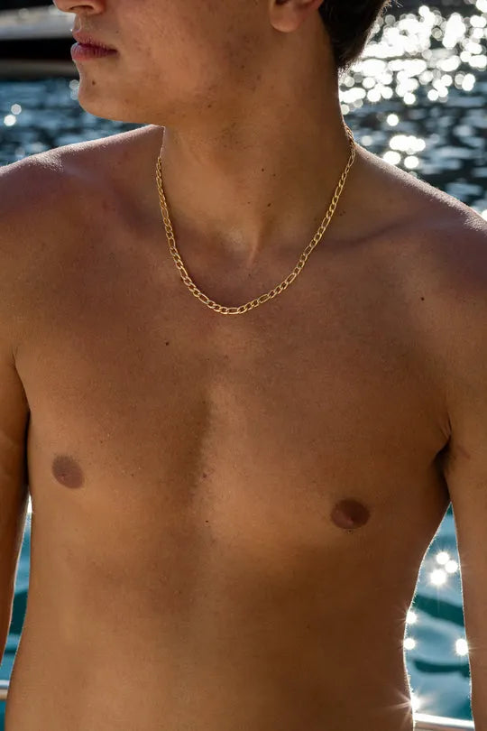 a shirtless man standing next to a body of water