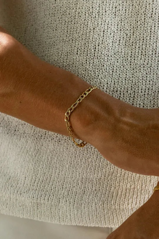 a woman wearing a gold chain bracelet