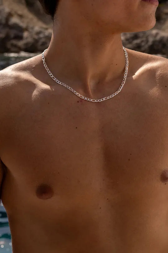 a shirtless man with a chain around his neck