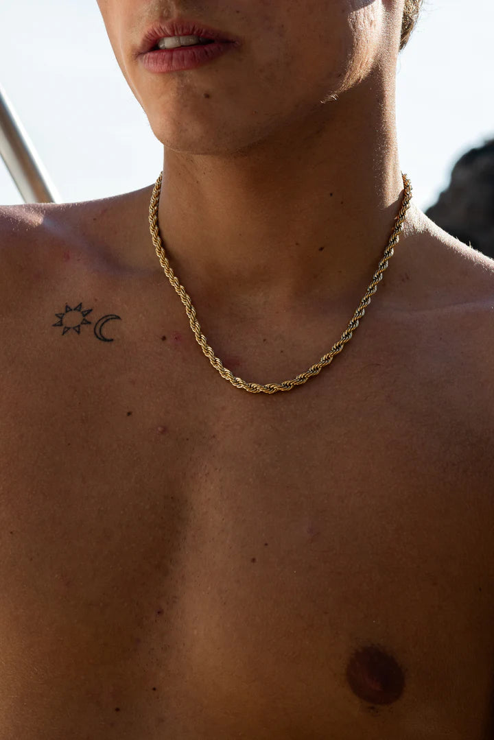 a shirtless man with a chain around his neck