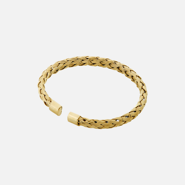 a gold braided bracelet on a white background