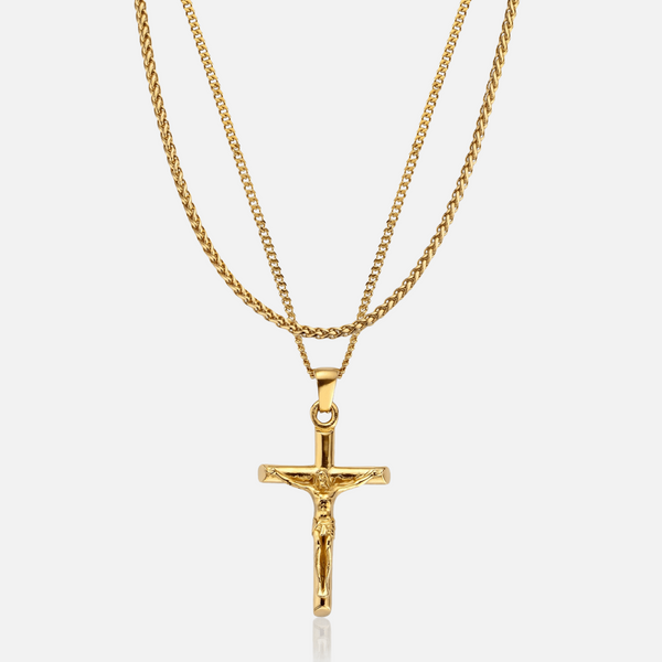 a gold cross necklace on a white background